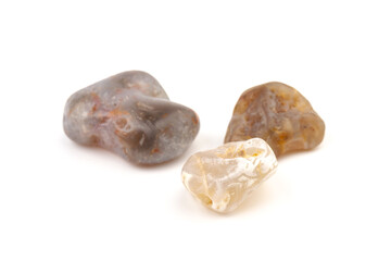 Multicolored gemstones, tumbled minerals. Bostwan agate of various sizes on a white background.