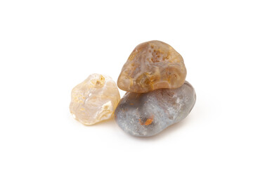 Multicolored gemstones, tumbled minerals. Bostwan agate of various sizes on a white background.