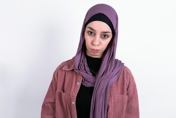 young beautiful muslim woman wearing hijab against white background depressed and worry for distress, crying angry and afraid. Sad expression.