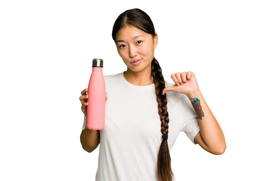 Young asian woman holding a pink thermo isolated feels proud and self confident, example to follow.