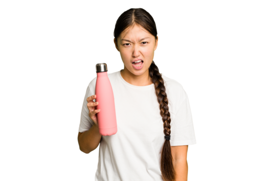 Young asian woman holding a pink thermo isolated screaming very angry and aggressive.