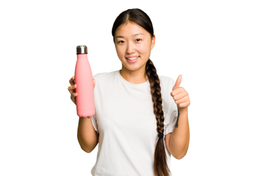 Young asian woman holding a pink thermo isolated smiling and raising thumb up