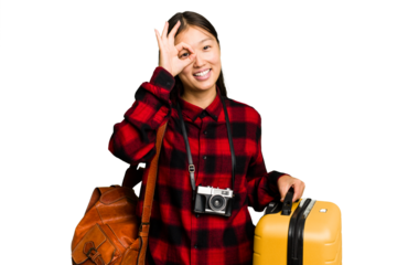 Traveler asian woman holding a suitcase isolated excited keeping ok gesture on eye.