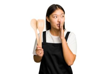 Young asian cook woman isolated is saying a secret hot braking news and looking aside