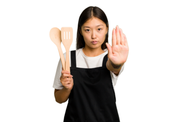 Young asian cook woman isolated standing with outstretched hand showing stop sign, preventing you.