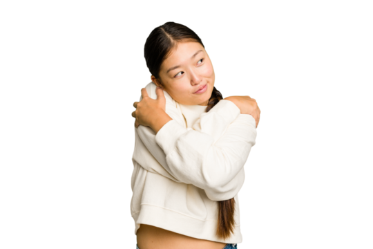 Young Asian woman isolated hugs, smiling carefree and happy.