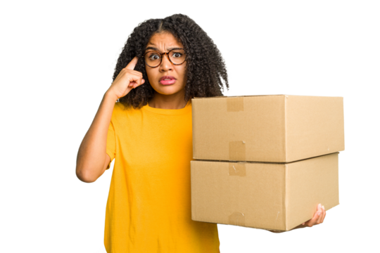 Young african american woman moving to other house while picking up a box full of things isolated showing a disappointment gesture with forefinger.