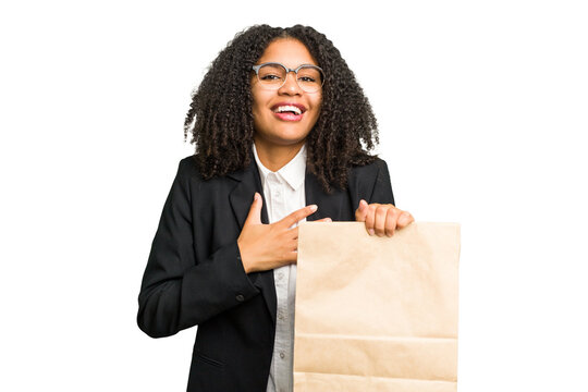 Young African American Business Woman Holding A Take Away Bag Isolated Laughs Out Loudly Keeping Hand On Chest.