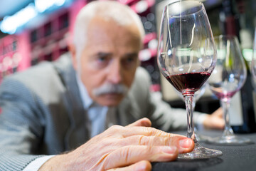 senior male customer with wine in cafe