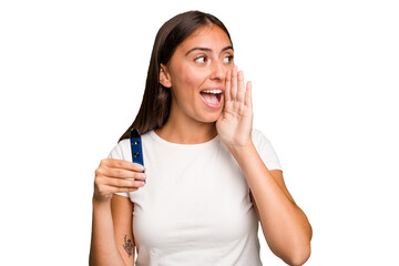 Fototapeta premium Young caucasian woman holding a electronic cigarette shouting and holding palm near opened mouth.