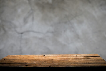 Empty wooden board on table top and blur inside over stucco wall blur background, mock up for display of goods.