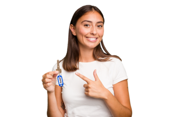 Young caucasian woman holding a home keys isolated smiling and pointing aside, showing something at blank space.