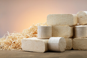 different  pressed sawdust fuel briquettes and sawdust on wooden surface. concept of alternative energy.