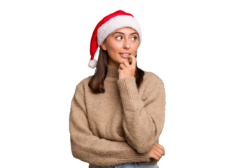 Young caucasian woman celebrating christmas wearing a santa hat isolated relaxed thinking about something looking at a copy space.