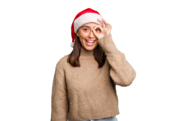 Young caucasian woman celebrating christmas wearing a santa hat isolated excited keeping ok gesture on eye.