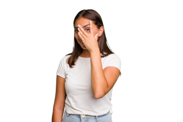Young cute caucasian woman isolated blink at the camera through fingers, embarrassed covering face.