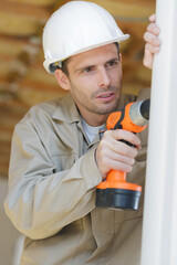 male construction worker using cordless drill