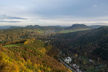 Fototapeta na wymiar Autumn Saxon Switzerland view from the hill. City under the sunset sky in the valley between the hills. High quality photo