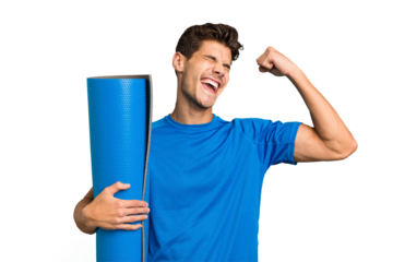 Young caucasian sport man holding a mat isolated raising fist after a victory, winner concept.