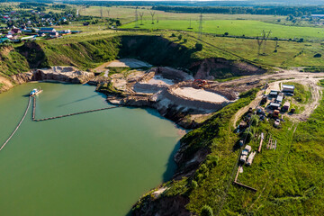 Sand mining in a flooded sand pit with a floating dredger, aerial view