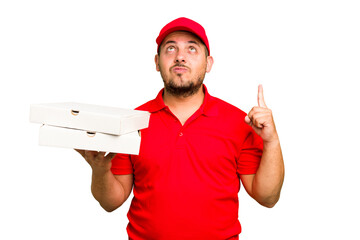 Pizza delivery caucasian man with work uniform picking up pizza boxes isolated pointing upside with opened mouth.