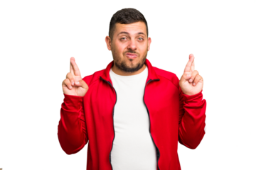 Young caucasian man isolated crossing fingers for having luck