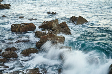 Waves breaking on the rocks with long exposure image