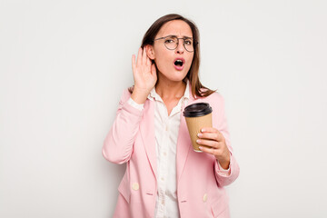 Business caucasian woman holding a take away coffee isolated on white background trying to listening a gossip.