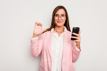 Fototapeta premium Business caucasian woman holding a mobile phone isolated on white background feels proud and self confident, example to follow.