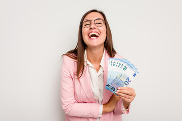 Business caucasian woman holding banknotes isolated on white background laughing and having fun.