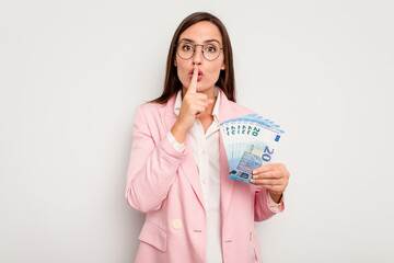 Business caucasian woman holding banknotes isolated on white background keeping a secret or asking for silence.