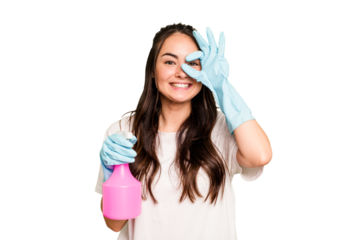 Young cleaner caucasian woman isolated on green chroma background excited keeping ok gesture on eye.