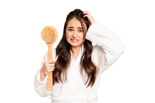 Young caucasian woman holding shower brush isolated on green chroma background being shocked, she has remembered important meeting.