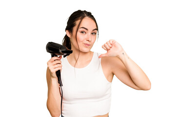 Young caucasian woman holding a hairdryer on green chroma background feels proud and self confident, example to follow.