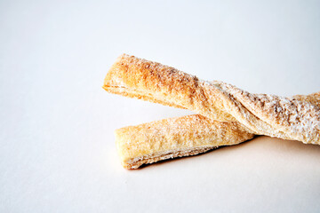 Puff pastry sticks with cinnamon on white background