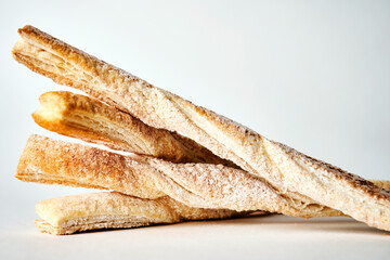 Puff pastry sticks with cinnamon on white background