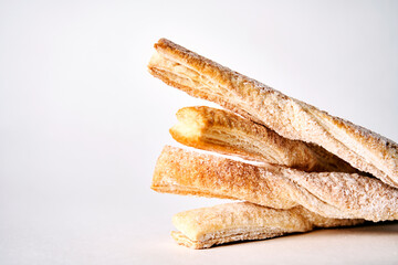 Puff pastry sticks with cinnamon on white background