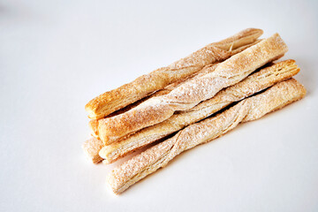 Puff pastry sticks with cinnamon on white background