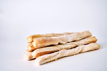 Puff pastry sticks with cinnamon on white background