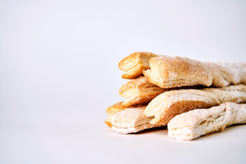 Puff pastry sticks with cinnamon on white background