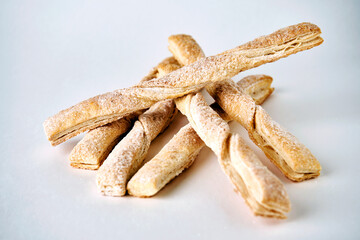 Puff pastry sticks with cinnamon on white background