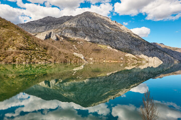 Naklejka na ściany i meble Beautiful reservoir and mountain landscape in Riano. Mirror effect. Spain