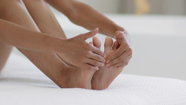 Legs self care. Close up shot of woman rubbing cooling healing cream on soles, massaging her tired feet, empty space