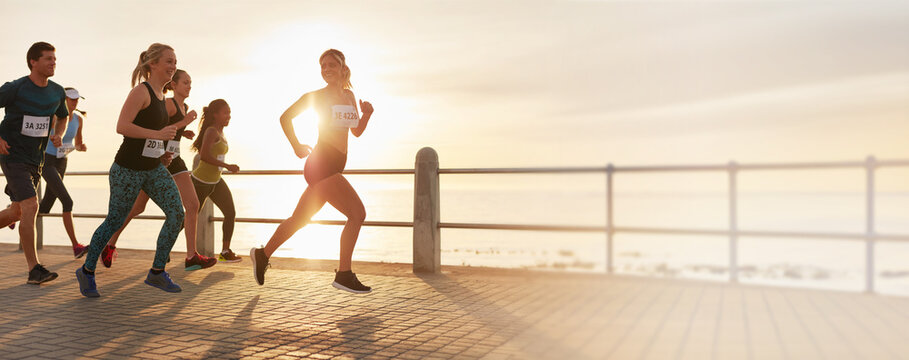 Male and female runners running competing in marathon race as they run for fitness and healthy active lifestyle