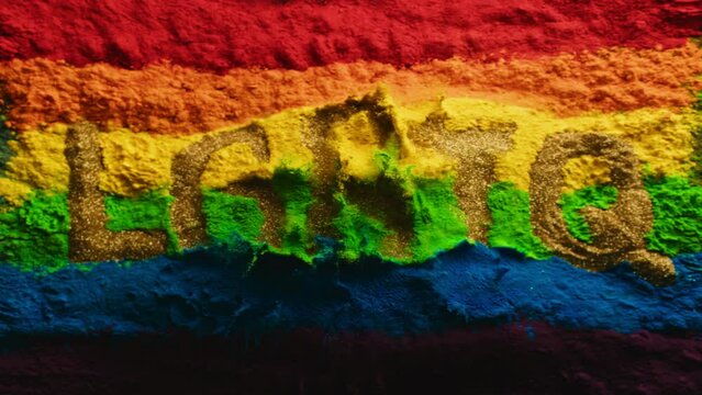 Super slow motion shot of color powder explosion rainbow flag with lgbtq text. Filmed on high speed cinema camera at 1000fps 4k prores 422
