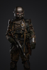 Fototapeta na wymiar Shot of post apocalyptic soldier dressed in armour and gas mask holding shotgun.