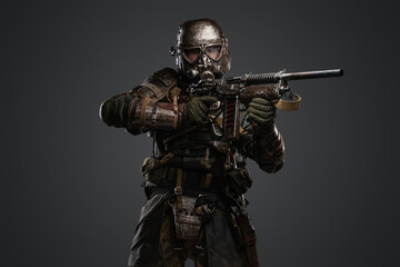 Studio shot of isolated on grey background soldier after armageddon aiming shotgun.