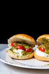 Italian Caprese sandwiches with fresh cherry  tomatoes, mozzarella cheese and pesto sauce.