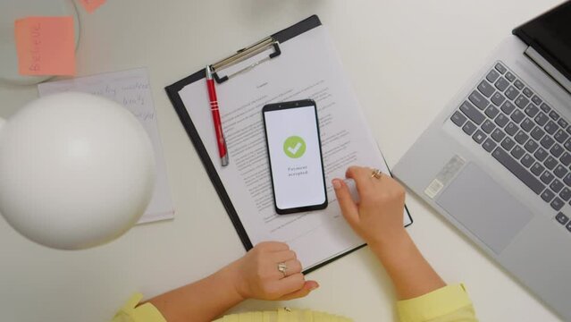 Top view woman working from home paying online from phone. Happy costumer accepted payment online contactless.