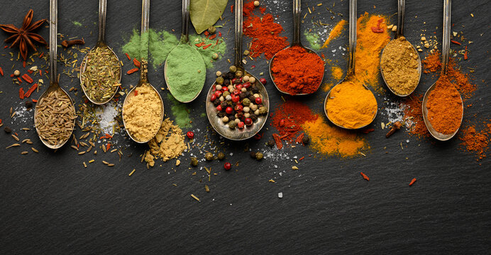 Various seasonings and spices on black stone plate